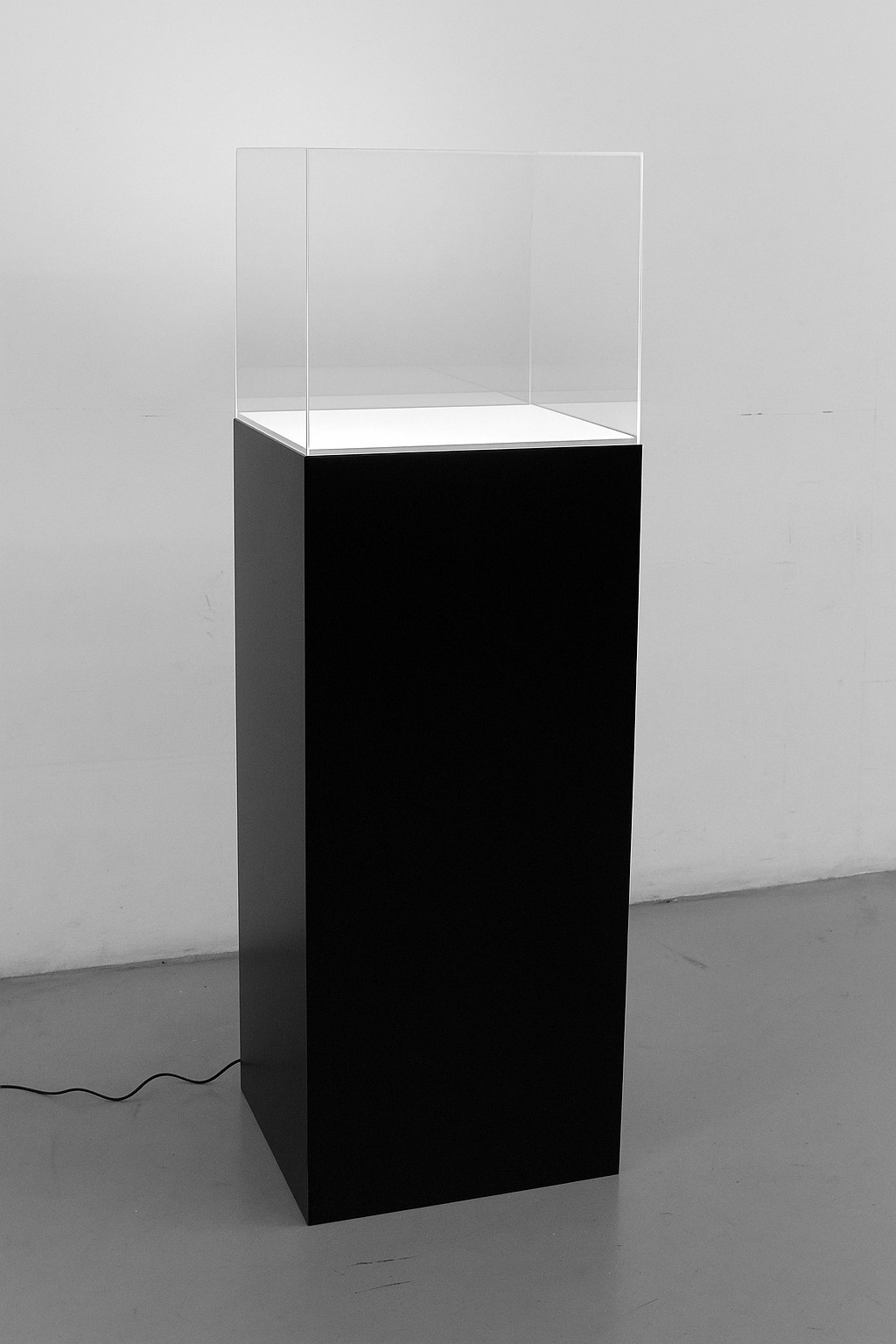 Totem da terra costituito da colonna laccata nera e teca in plexiglass: sistema di illuminazione led al piano
